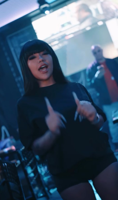 A frame from LMP's reel: a woman in black with a fringe dancing toward the camera, a man filming on his phone behind her