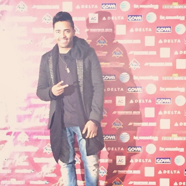 Karlos Rosé at Amor a Nuestra Música, in front of a sponsor backdrop with the Goya, Delta, AT&T and SBS Entertainment logos