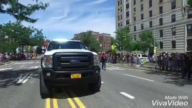 LMP's white pickup truck on the parade route, crowds on the sidewalks