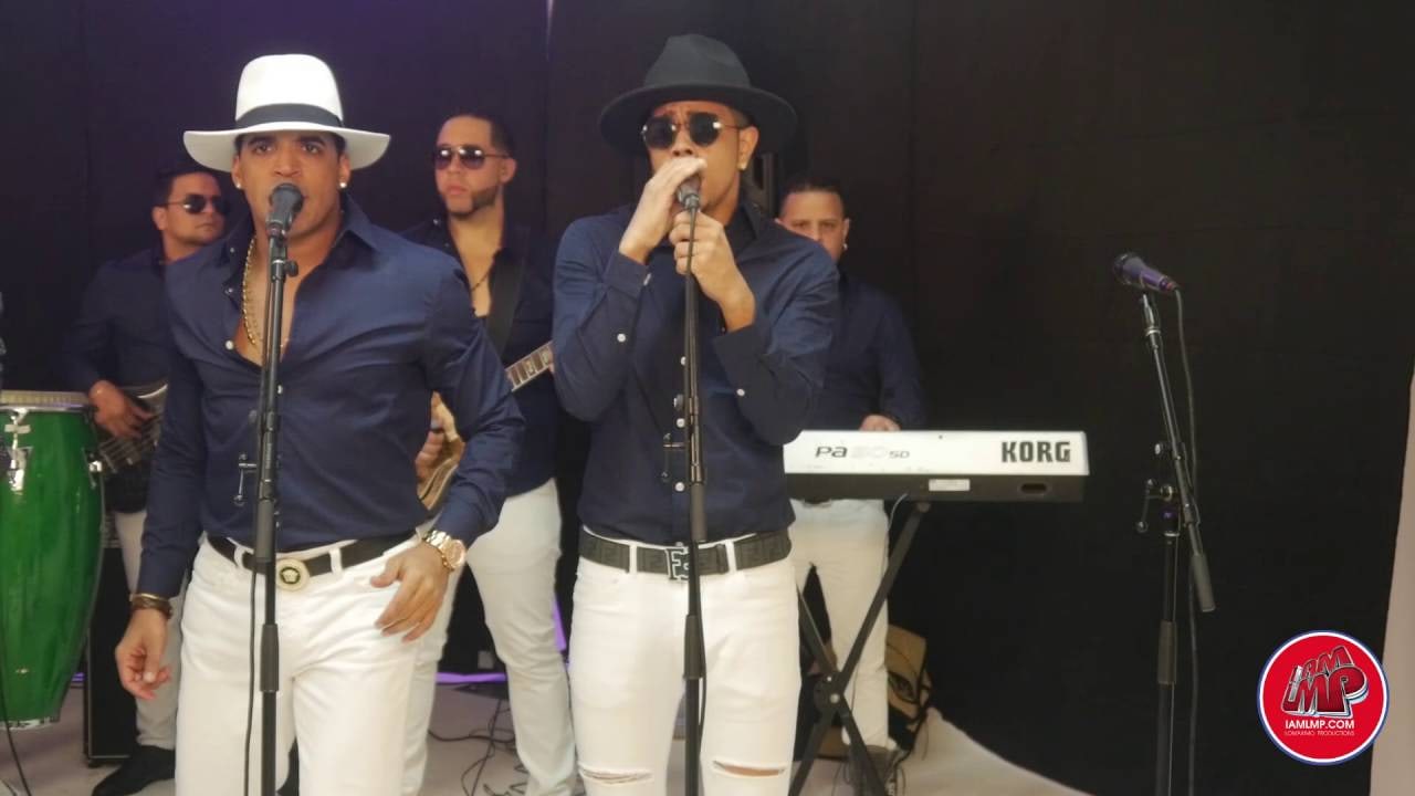 Nexo's two singers at the mics, one in a white hat and one in a black hat, the band behind them, in their 2016 LMP Live Session