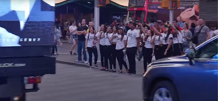 A crowd in DALE shirts beside the screen truck