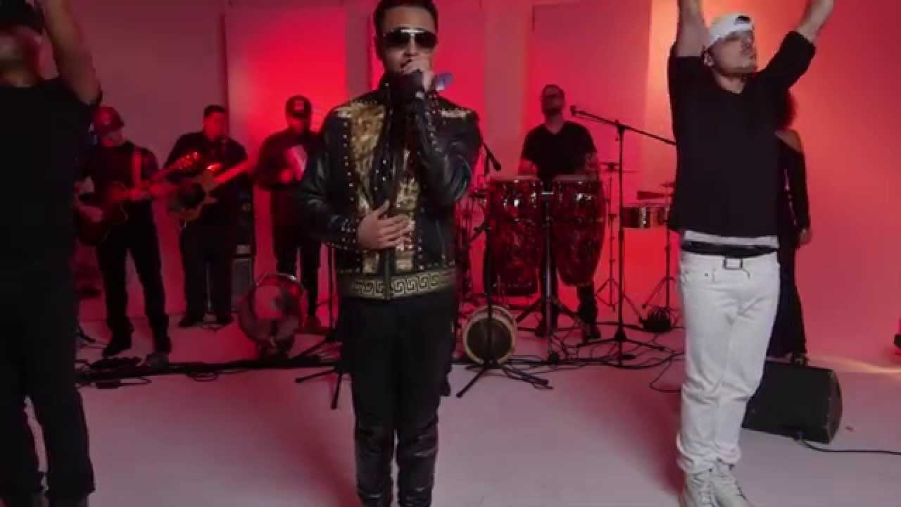 Toby Love at the mic in his studded jacket, the band and a dancer behind him